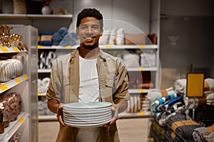 Portrait of man carrying purchased plate stack