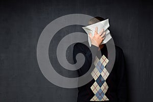 Portrait of man covering his face with paper sheet