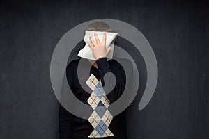 Portrait of man covering his face with paper sheet