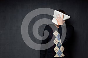 Portrait of man covering his face with paper sheet