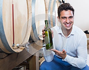 Portrait of man customer having bottle of wine in shop