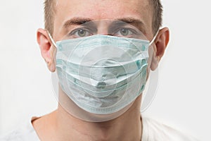 Portrait of a Man in disposable mask. Doctor in styryl surgical mask. Close up