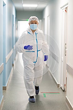 Portrait of man doctor in protective clothes during coronavirus pandemic in corridor hospital. Epidemic, pandemic of coronavirus