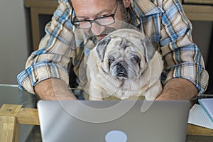 Portrait of man and dog working together at home with laptop computer - concept of free smart work lifestyle people - caucasian