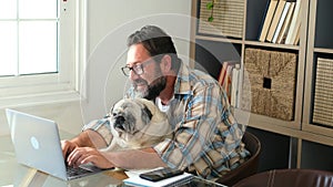 Portrait of man and dog working together at home with laptop computer - concept of free smart work lifestyle people - caucasian