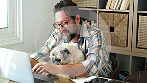 Portrait of man and dog working together at home with laptop computer - concept of free smart work lifestyle people - caucasian