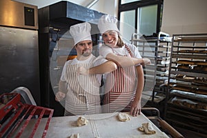 Portrait of man with down syndrom and his colleague in bakery. Concept of integration people with disability into