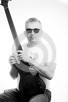 Portrait of a man with an electric guitar in his hands, made in a high key