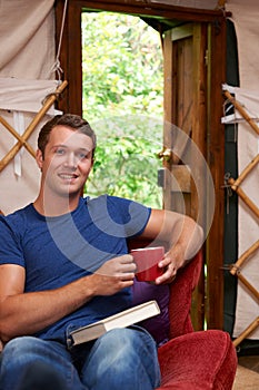 Portrait Of Man Enjoying Luxury Camping Holiday In Yurt