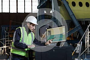 Portrait of a man , factory engineer in work clothes controlling the work process at the airplane manufacturer.