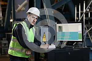 Portrait of a man , factory engineer in work clothes controlling the work process at the airplane manufacturer.