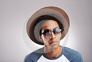 Portrait, man and fashion with funky sunglasses in studio for designer casual hat style for creative eyewear. Hipster