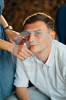 Portrait of man. female hands touching guy face