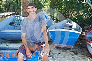 Portrait, man and fisherman on boat by beach outdoor in summer or smoking cigarette in nature. Fishing, mature person