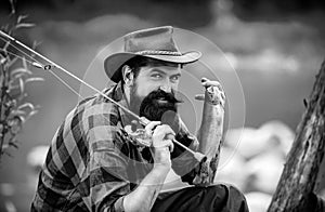 Portrait of man fishing. Fisherman with rod, spinning reel on river bank. Man catching fish, pulling rod while fishing