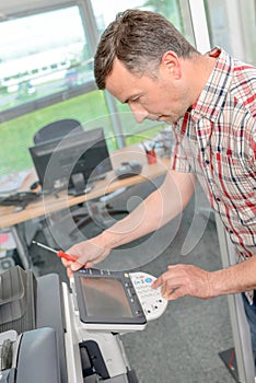 Portrait man fixing photocopier