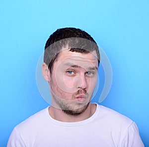 Portrait of man with funny face against blue background