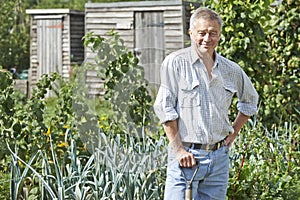 Portrait Of Man Gardening On Allotment