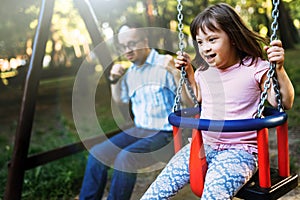 Portrait of man and girl with down syndrome swinging