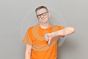 Portrait of man giving thumb down signs of disapproval and smiling