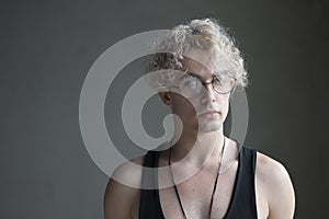 Portrait of a man with glasses on a gray background.Young blond man, northern photo