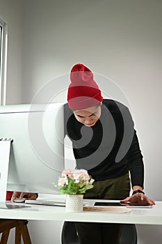 Portrait of a man graphic designer is working on computer while using graphic tablet at desk.