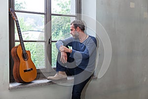 Portrait of man with guitar, the industrial location