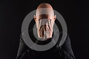 Portrait of a man hand cover the eyes on balck background