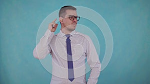 Portrait man with hearing impairment with a hearing aid on a blue background