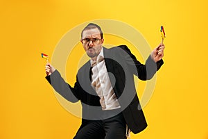 Portrait of man in his 30s wearing glasses, yarmulke and playing with noisemaker, gragger, expressing emotions against