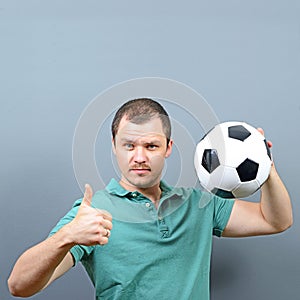 Portrait of man holding football with thumb up - Football fan supporter or player concept