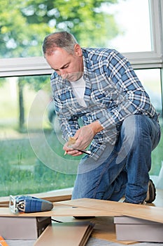 Portrait man installing wood floor