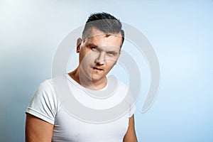 Portrait of a man on a light background close-up. Emotion is the importance, the superiority. The concept of body language, human photo