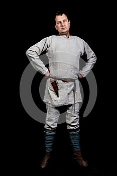 Portrait of a man in linen old clothes: shirt, unbleached linen pants, windings