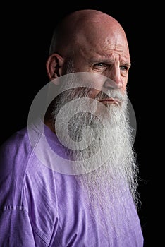 Portrait of man with long gray beard wearing purple t-shirt close-up shot