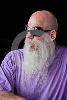 Portrait of man with long gray beard wearing purple t-shirt and sunglasses close-up shot