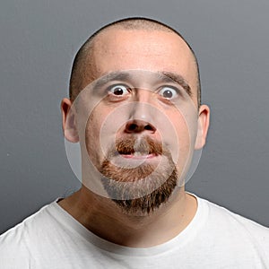 Portrait of a man making funny face against gray background