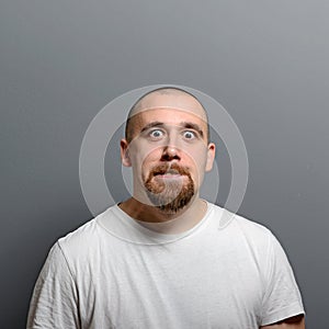 Portrait of a man making funny face against gray background