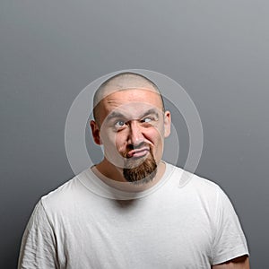 Portrait of a man making funny face against gray background