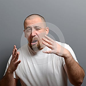 Portrait of a man making funny face against gray background