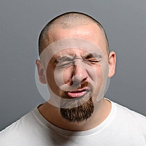 Portrait of a man making funny face against gray background