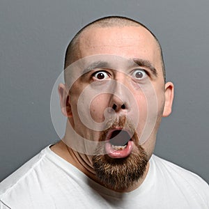 Portrait of a man making funny face against gray background