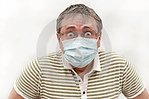 Portrait of a man in medical mask with glasses and bulging eyes. Humor, emotion
