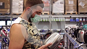 Portrait of a man in a medical protective mask at a home appliance store
