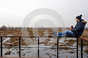 Portrait of a man in nature with a thermos