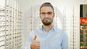 Portrait of man in new glasses in optical store