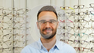 Portrait of man in new glasses in optical store