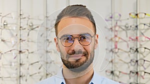 Portrait of man in new glasses in optical store