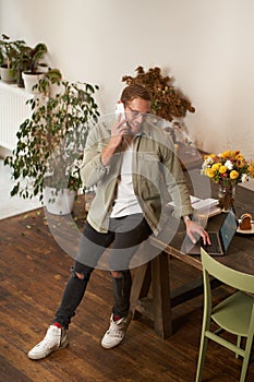 Portrait of a man in office, businessman making a phone call, having a conversation over the phone, receive a call