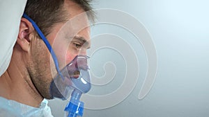 portrait of a man in an oxygen mask who lies on a bed in a hospital